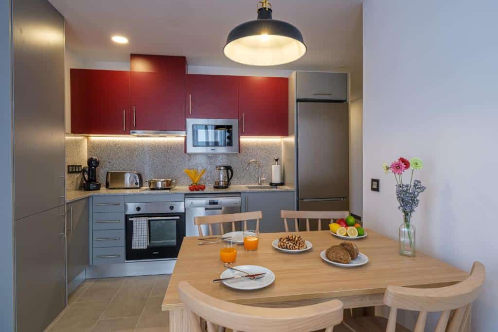Foto de la cuina equipada d'un apartament de dissenyada per a 4 persones, amb tot el necessari per a preparar menjars durant l'estada a Tarragona. Espai modern i funcional, ideal per a famílies o grups de turistes que busquen allotjament còmode i pràctic.