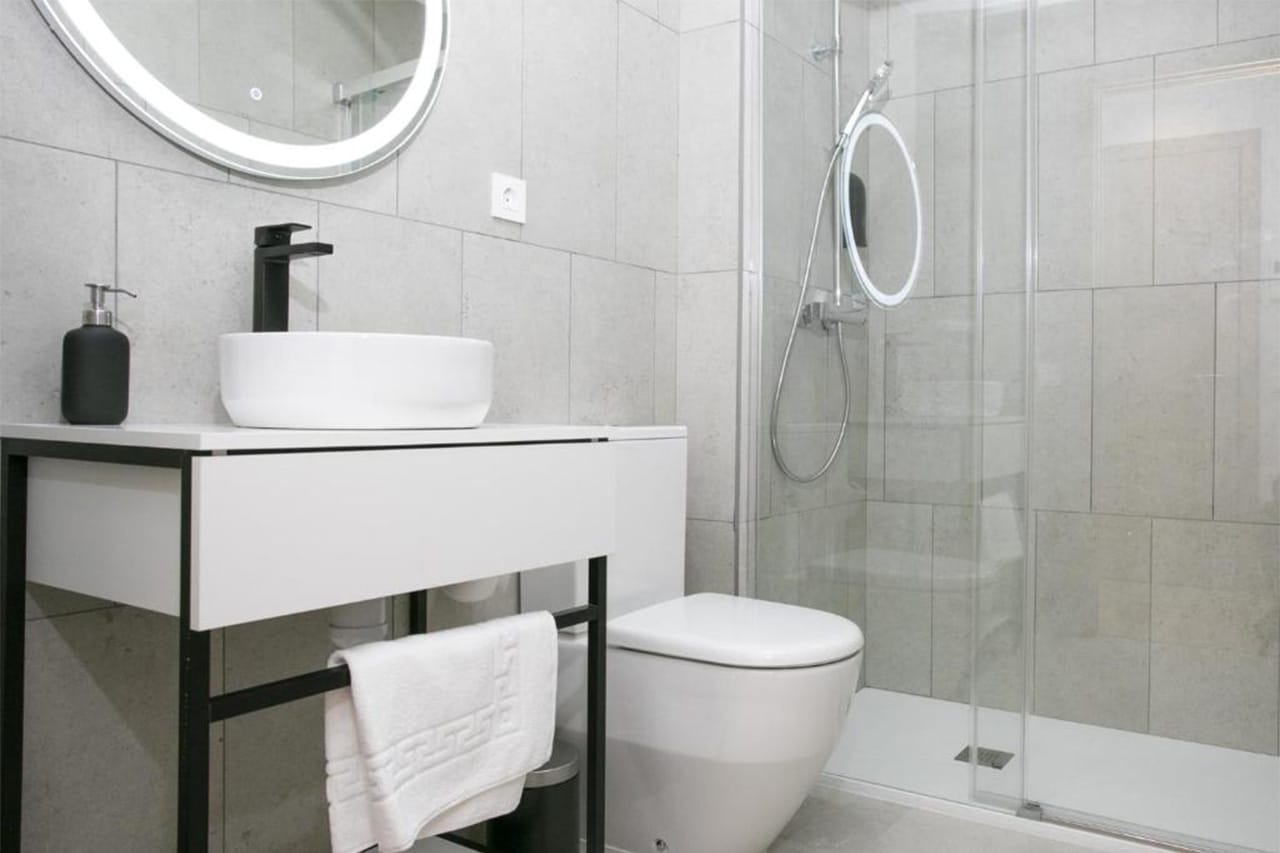 Bany amb plat de dutxa i griferia moderna a ideal per a estades llargues o curtes a Tarragona, amb instal·lacions modernes i confortables.