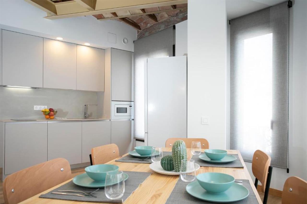 Cuina amb taula per a 6 persones, ideal per a estades llargues o curtes a Tarragona, amb espai per a menjar i gaudir en grup.