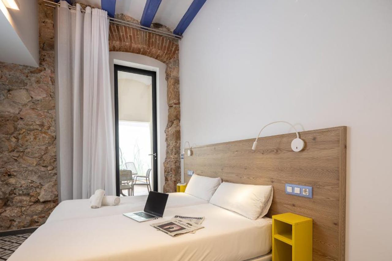 Habitació espaiosa amb llit de matrimoni (compost per dos llits individuals ajuntats) i accés a terrassa en els baixos de TGNA Cervantes 8, ideal per a estades curtes o llargues a Tarragona.