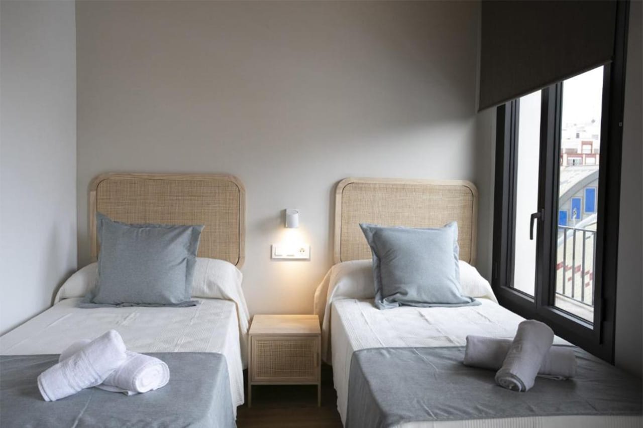 Foto de l'interior d'un àtic dúplex amb un llit de matrimoni i accés directe a la terrassa exterior. Un espai ampli i còmode per a 4 persones, ideal per gaudir de la ciutat i descansar amb total comoditat.