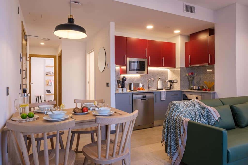 Apartaments Reial Foto del cuina-menjador d'un apartament de 2 habitacions per a 4 persones a TGNA Reial 1, amb sofà i televisió. Espai lluminós i acollidor ideal per a estades familiars o en grup a Tarragona.