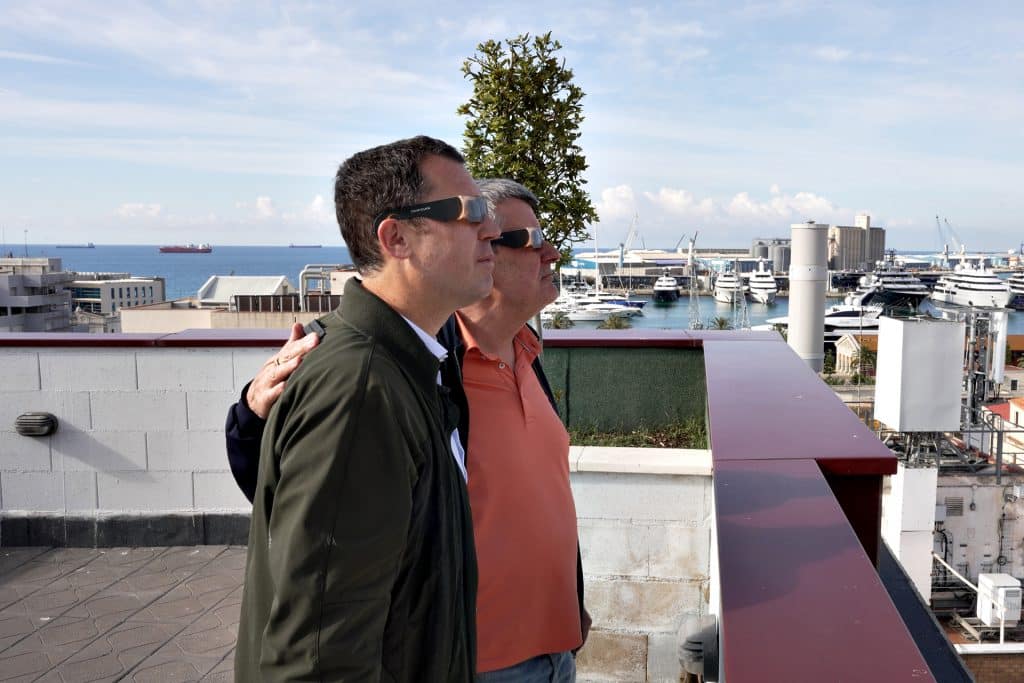 Directors de l'Òptica Fullana i TGNA Tarragona Apartaments mirant la posta de sol amb ulleres homologades, simulant l'eclipsi solar total a Tarragona des del terrat de TGNA Reial 1.