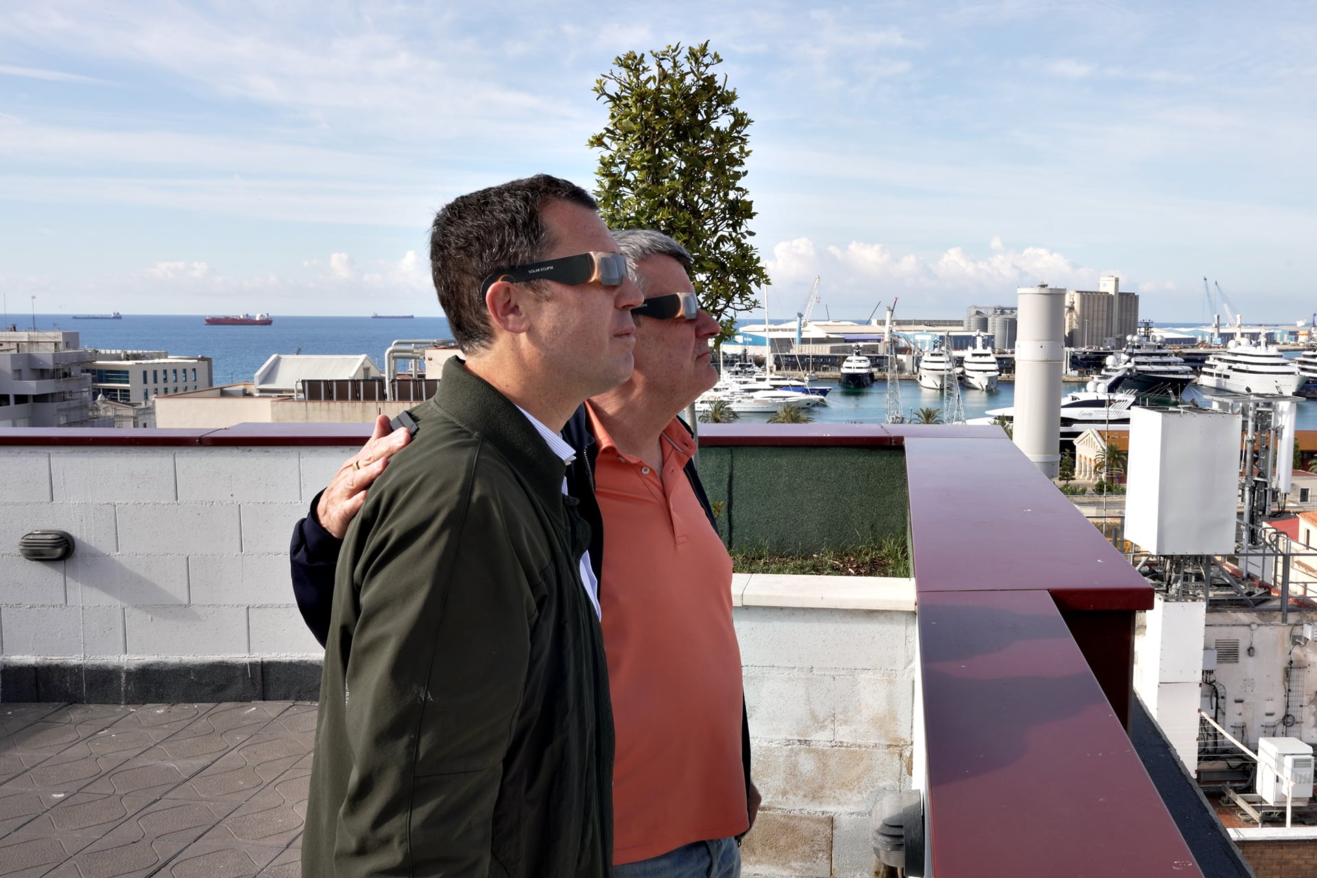 Directors de l'Òptica Fullana i TGNA Tarragona Apartaments mirant la posta de sol amb ulleres homologades, simulant l'eclipsi solar total a Tarragona des del terrat de TGNA Reial 1.